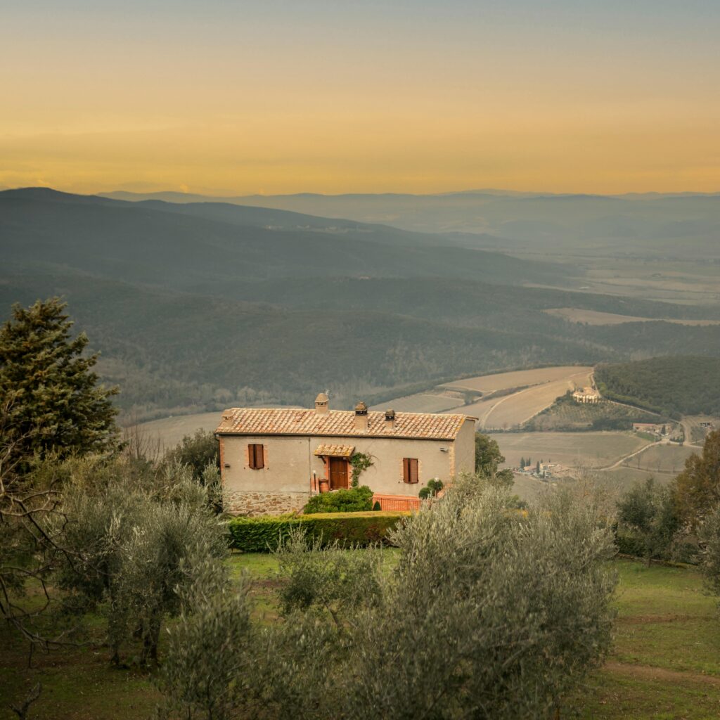 Exterior of aged stone residential house located in Chianti valley near vineyards against cloudless sunset sky